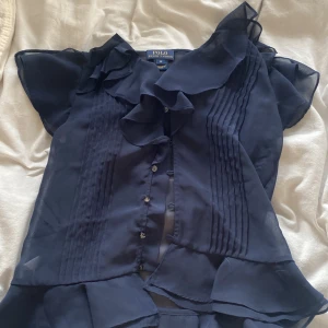 Navy blue blus från Ralph lauren!  - Super söt tunn blus från polo Ralph lauren💙blus med volanger och små detaljer på sidan samt knappar framtill 💙 säljer pga att den inte kommer till användning! 
