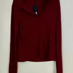 Vinröd långärmad topp från Lager 157 - Vinröd långärmad topp från Lager 157. V-ringad krage. Helt ny och oanvänd.