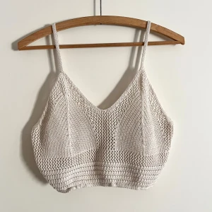 Crochet top - En knitted top i ljusbeige /crèmevit perfekt till sommaren! Toppen har ett resårband nertill. Har använts fåtal gånger. Alla använda plagg tvättas noga innan leverans! Det ar bara att skriva om du har några frågor! <3
