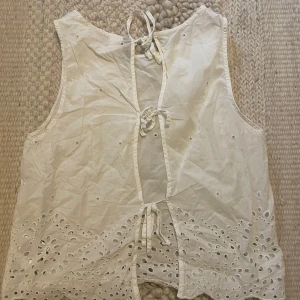 Vit blus med fina detaljer  - Vit blus perfekt till sommaren. Fina detaljer. Liten i storleken, mer en xs.