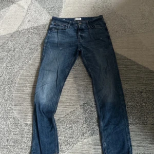 Jack & Jones Jeans - Snygga blå jeansbyxor med en klassisk look. De har en bekväm passform och är perfekta för en avslappnad stil. Midjan är märkt med storlek 31/32.