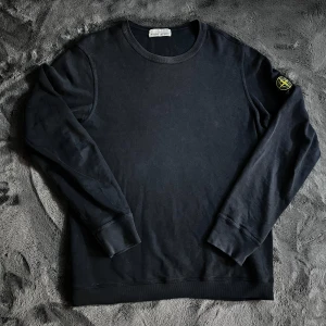 Stone Island tröja  - Säljer en mörkblå tröja från Stone Island med deras ikoniska märke på ärmen. Självklart äkta, har några små skador längst ut på ena ärmen men inget som syns vid användning, annars bra skick. Skick 6/10, Storlek L. Pris går att diskutera✅