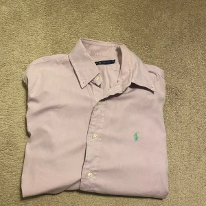 Ralph lauren skjorta  - Säljer denna tvär feta rosa ralph lauren skjortan i storlek M, skjortan är i använt skick men inga defekter. Om du har minsta lilla fråga är de bara att skriva mvh Alexander 