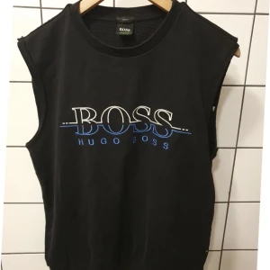 Retro väst Hugo Boss - Väst från Hugo Boss med tryck på framsidan Slim fit Strl M Modellen ser ut som en avklippt sweatshirt