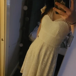 Studentklänning - Säljer en elegant vit spetsklänning från Chiara Forthi. Klänningen har en vacker spetsdesign med korta ärmar och en hjärtformad urringning. Perfekt för studenten! 💫 Köpt på Bubbelroom.