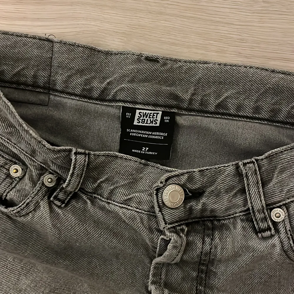 Snygga grå jeans från Sweet Sktbs med klassisk femficksdesign och knappgylf. Perfekta för en avslappnad stil med en skandinavisk touch. Köpa på junkyard. Org pris: 800. Farkut & Housut.