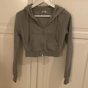 Grå hoodie från H&M Divided - Säljer en ljusgrön zip hoodie från H&M i storlek XS. Den är croppad med dragkedja framtill och har en mysig huva, den ser ut att vara liten men passar skit snyggt till outfits🫶🏼🫶🏼