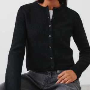 Svart kofta  - Snygg svart kofta med knappar framtill. Den är långärmad och har en klassisk design som passar perfekt till olika outfits. Perfekt för kyligare dagar.