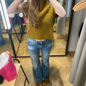 Jeans från Zara - Utsvängda/raka Jeans från Zara med en slitning detalj. Medelhög midja