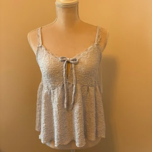 Ljusblå topp från Gina Tricot - Säljer en  ljusblå sommar topp från Gina Tricot med knytning framtill och smala axelband. Toppen har en luftig passform och är perfekt för varma dagar! Använd endast en gång.