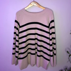Beige och svart randig tröja - Säljer en snygg beige tröja med svarta ränder från Tenhults egna butik. Tröjan har en rund hals och långa ärmar, perfekt för en stilren look. Den är oversized och är gjord i ett mjukt material som känns skönt mot huden.