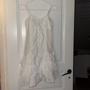Vit sommarklänning med volanger - Jag säljer en jätte fin vit sommarklänning💞 jag säljer den för att den är för liten för mig annars hade jag aldrig sålt den. Den kommer från när jag var lite mindre så därför vet jag inte vilket märke💞 vid fler frågor så är det bara att fråga!!❤️