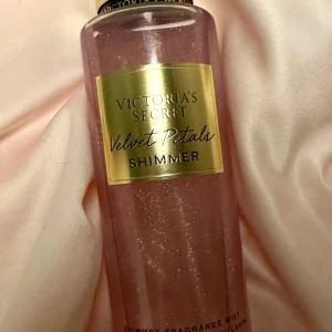 Victoria's Secret Velvet Petals Shimmer mist - Säljer en glittrande doftmist från Victoria's Secret, Velvet Petals Shimmer. Flaskan är rosa med en gyllene etikett och innehåller noter av frodiga blommor och mandelglasyr. Perfekt för att ge en skimrande touch. På sista bilden ser du hur mycket det finns kvar 💜