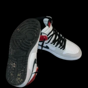 Nike Air Jordan 1 Retro High Light Smoke Grey - Snygga Nike Air Jordan 1 med en klassisk design i vitt, svart och rött. Skorna har en hög siluett med svart snörning