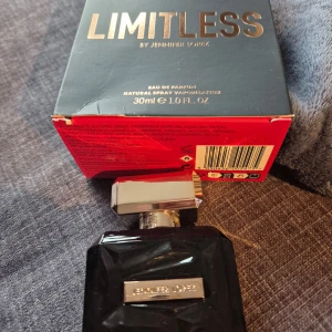 Limitless Eau de Parfum av Jennifer Lopez - Limitless Eau de Parfum av Jennifer Lopez i en elegant svart flaska med silverdetaljer. Flaskan har en stilren design med en fyrkantig form och ett silverlock. Parfymen kommer i en förpackning om 30 ml.