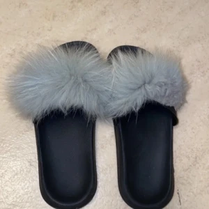 Tofflor med grå päls - Svarta tofflor med mjuk grå pälsdetalj på ovansidan. Passar 37-39. 