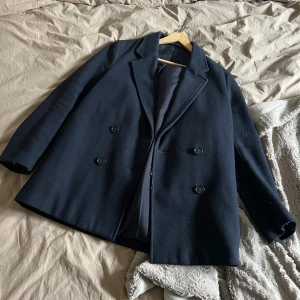 Filippa K kappa - En marinblå kappa från Filippa K!  Köpte den begagnad för 2 år sen, och har knappt använt den då den är lite tajt. Bra kvalitet och inga skador/slitage som jag är medveten om. Köpte den för ca 700kr, säljer för hälften!  Storlek: xs 