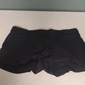 Säljer ett par svarta shorts i storlek 164. Materialet känns mjukt och bekvämt, och de har en enkel design utan mönster eller detaljer.