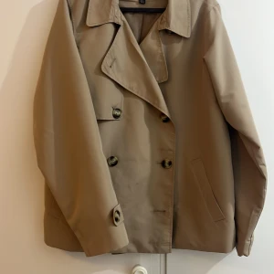  kort trenchcoat - Säljer min  nya Vero Moda  kort trenchcoat. Som jag glömde returnera. Använts en gång. 
