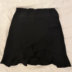 Svart kjol - Söt tight kjol med volangdetaljer som passar både festligare tillfällen och vardagligt! Kjolen är svart och knappt använd. Pris kan diskuteras 🌸🌸