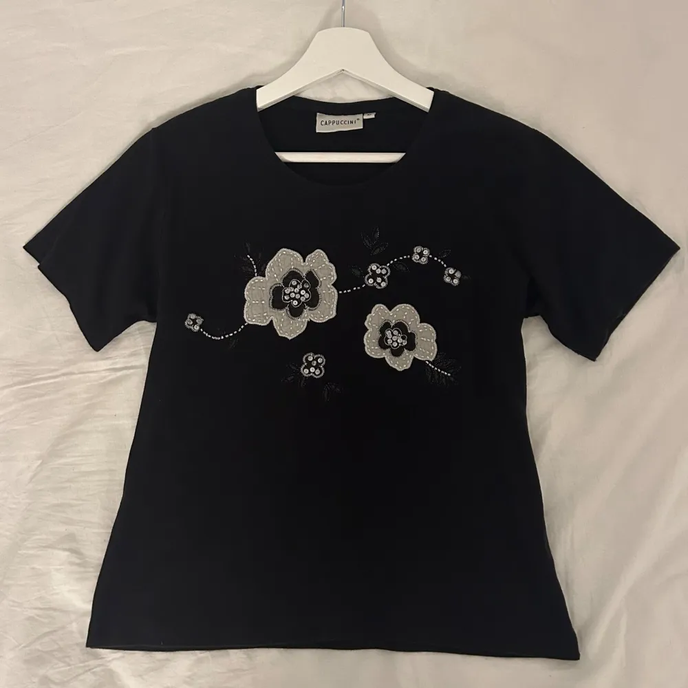 Säljer den här söta T-shirten! Blommorna har pärlor och paljetter på sig 💓. T-shirts.