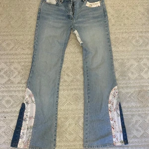 Så coola utsvängda jeans med fina lappar! - Utsvängda jeans köpta second hand med fina lappar! Materialet är i bra kvalitet och jag har aldrig använt de då de är för små tyvärr.  Midja: ca 36 cm (x2) Längd: ca 102 cm Innerben: ca 80 cm Höjd från gren: ca 21 cm Bredden vid fot: ca 27 cm