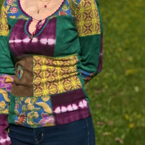 Färgglad patchwork tröja - Säljer en unik och färgglad patchwork tröja med ett coolt mönster i grönt, lila och gult. Tröjan har långa ärmar och en dekorativ snörning vid halsen. Perfekt för dig som vill sticka ut med en bohemisk stil!