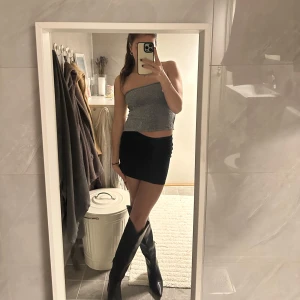 Glittrig tubtopp med knytband - Snygg glittrig tubtopp i silver med knytband i ryggen. Perfekt för en utekväll eller fest. Storlek XS/S