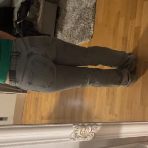 Grå bootcut jeans - Säljer ett par snygga grå bootcut jeans mid waist. De har en klassisk femficksdesign och dragkedja fram. Bra skick, inga fläckar. 