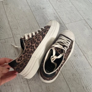 Leopardmönstrade sneakers - Snygga sneakers med leopardmönster och vita snören. Skorna har en tjock vit sula som ger extra komfort och stil. Nästan helt nya bara använda en gång