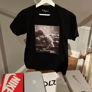 Svart t-shirt med tryck från Marziano - Snygg svart t-shirt från Marziano med ett coolt tryck på framsidan och ett inspirerande citat på baksidan. 