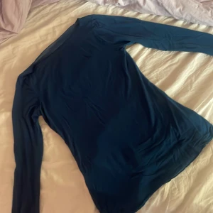 Blågrön långärmad tröja från Intimissimi💙💚 - Säljer en elegant mörkblå långärmad tröja från Intimissimi. Tröjan är tillverkad i kashmir, vilket ger en lyxig känsla. Perfekt för kyligare dagar. Inga defekter men litet tecken på användning!🥰