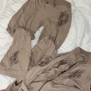 Tracksuit sett från Vertigo Paris - Säljer low waist byxor med matchande kofta. Köpt i USA för flera år sen men har knappt använt dem. Y2k stil. Skriv privat om du vill se fler bilder. Hittar inte exakta priset men likande sett från märket hittade jag på ebay för 600-800 kr ca. 