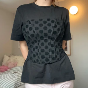 Svart prickig korsett - Trendig svart korsett med prickar. Jag har använt den både över T-shirt och som enbart korset (se bilderna). 
