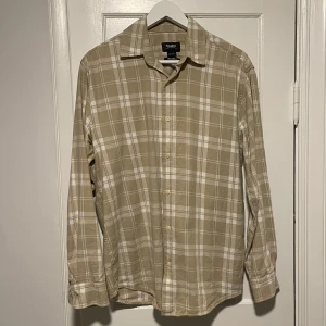 Beige flannelskjorta  - Snygg beige flanellskjorta från Pull&Bear i en avslappnad passform. Mycket bra skick. Storlek xs. Skriv vid frågor eller fler bilder. 