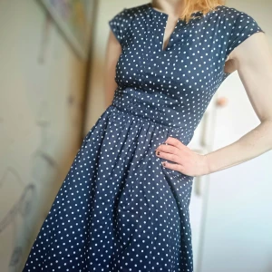 Blå prickig klänning från Bondelid - Charmig blå klänning med vita prickar från Bondelid. Den har en dragkedja framtill och en söt, figurnära passform. Perfekt för en somrig look!