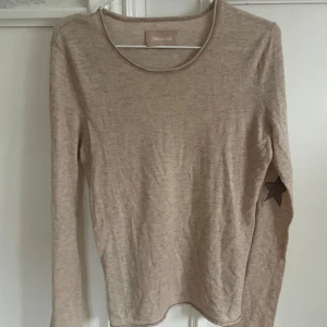Beige långärmad tröja från Zadig - Säljer en stilren beige långärmad tröja från Zadig. Tröjan har en unik detalj med en stjärna på ärmen. Perfekt för en avslappnad look.