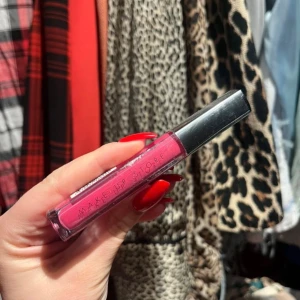 Rosa läppglans från Make Up Store - Snyggt rosa läppglans från Make Up Store med en glansig finish. Perfekt för att ge läpparna en färgstark look. Kommer i en smidig tub med svart lock. Helt ny!