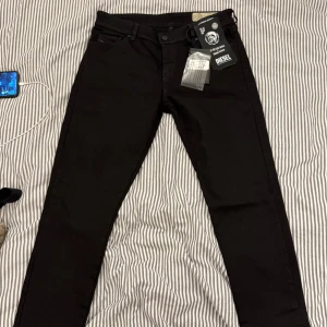 Svarta jeans från Diesel - Snygga svarta jeans från Diesel med en klassisk design. De har en normal passform och är tillverkade i 100% denim. Perfekta för en stilren look.