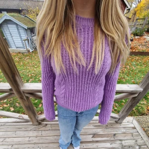 Lila stickad tröja - Säljer en mysig lila stickad tröja med ribbad design. Tröjan har långa ärmar och en rund halsringning, perfekt för kyligare dagar. Endast testad och inte använd så i fantastiskt skick. Osäker på storlek men skulle uppskatta till S.