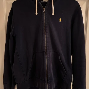 Mörkblå hoodie från Polo Ralph Lauren - Säljer en zip från Polo Ralph Lauren med dragkedja och logga på bröstet. Använd typ 5 gånger