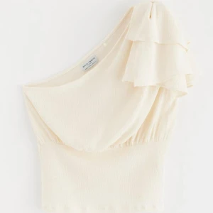 One shoulder topp - En fin on shoulder topp med rosett från Lindex. Använd en gång och i väldigt bra skick, säljer pga att den inte kommer till användning. Storlek XS, original pris 299. (Lånad första bild)💗