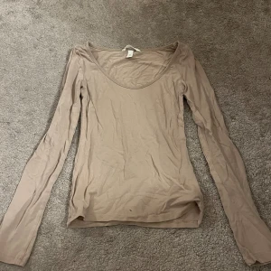 Beige långärmad h&m - Säljer en beige urringad långärmad❤️ Tröjan är köpt på h&m och har inga tecken på användning utom ett litet hål på framsidan längst ner. Matrialet är jättemjukt❤️