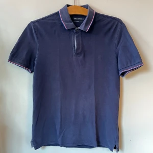 Marinblå Polo - Mörkblå polotröja från Marc O’Polo i (mans)storlek S. Bekvämt och stretchigt tyg, med lätt och ledigt fall. Ganska använd, men i bra skick. Färgen är lite blekt av tvättning och sol, vilket jag själv tyckt varit snyggt. Har haft på mig den som oversized. 