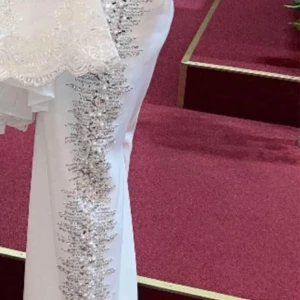 Vit klänning med paljettdetaljer - Elegant vit klänning med glittrande paljettdetaljer längs sidorna. Klänningen har en figurnära passform och är perfekt för festliga tillfällen. Den är ärmlös och har en stilren design som framhäver silhuetten. Liten i storlek. Använd endast ett par timmar.