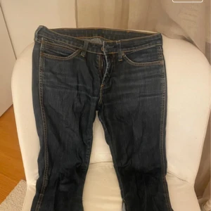Mörkblå jeans från Wrangler - Snygga mörkblå jeans från Wrangler. Egensydd bootcut med ett ljusare jeanstyg. Mycket bra skick, endast en liten slitning längst ner på benen.