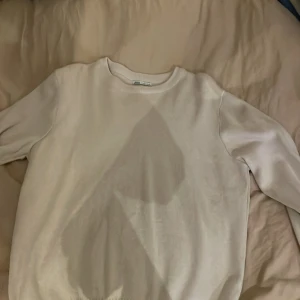 Vit/beige tröja från Zara - Säljer en stilren vit tröja från Zara. Tröjan har en klassisk design med rund hals och långa ärmar. Perfekt för en enkel och avslappnad look.