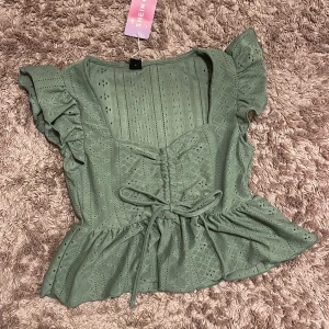 Grön blus från Shein - Söt grön blus med volangdetaljer och knytning framtill. 