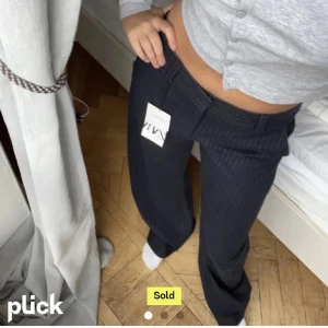 kostymbyxor från Zara - Snygga marinblå kostymbyxor från Zara med en klassisk passform. Byxorna har en elegant design med diskreta ränder och är perfekta för en stilren look. De är lågmidjade och har en rak stil som ger en tidlös känsla.