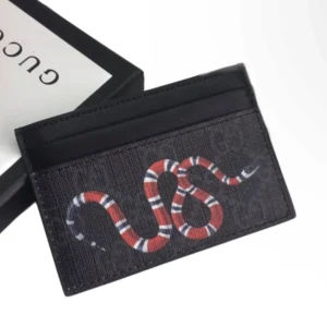 Svart kortfodral med ormmotiv från Gucci - Snyggt svart kortfodral från Gucci med ett iögonfallande ormmotiv i rött och vitt. Perfekt för att hålla dina kort organiserade med stil. Kompakt och lätt att bära med sig. Pris kan diskuteras